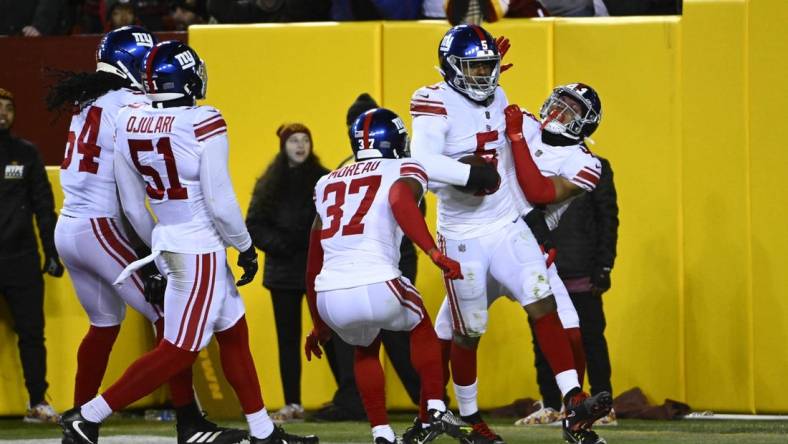 Dec 18, 2022; Landover, Maryland, USA; New York Giants defensive end Kayvon Thibodeaux (5) is congratulated by teammates after scoring a touchdown  against the Washington Commanders during the first half at FedExField. Mandatory Credit: Brad Mills-USA TODAY Sports