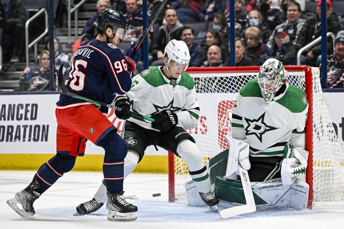 Dec 19, 2022; Columbus, Ohio, USA; Dallas Stars goaltender Jake Oettinger (29) makes a save with Columbus Blue Jackets center Jack Roslovic (96) and Stars defenseman Nils Lundkvist (5) in the crease in the first period at Nationwide Arena. Mandatory Credit: Gaelen Morse-USA TODAY Sports