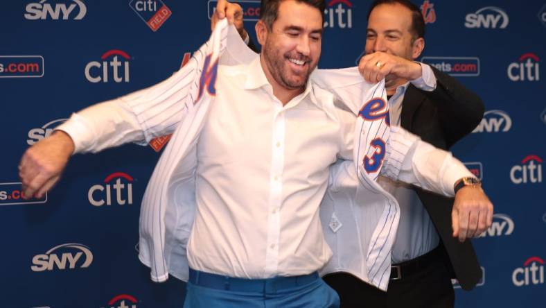 Dec 20, 2022; NY, NY, USA; New York Mets general manager Billy Eppler (right) assists pitcher Justin Verlander with his Mets jersey during a press conference at Citi Field. Mandatory Credit: Brad Penner-USA TODAY Sports