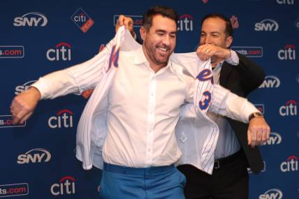 Dec 20, 2022; NY, NY, USA; New York Mets general manager Billy Eppler (right) assists pitcher Justin Verlander with his Mets jersey during a press conference at Citi Field. Mandatory Credit: Brad Penner-USA TODAY Sports