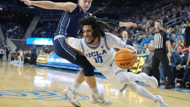 Dec 21, 2022; Los Angeles, California, USA; UCLA Bruins guard Tyger Campbell (right) dribbles the ball against UC Davis Aggies guard Leo DeBruhl in the second half at Pauley Pavilion presented by Wescom. UCLA defeated UC Davis 81-54. Mandatory Credit: Kirby Lee-USA TODAY Sports