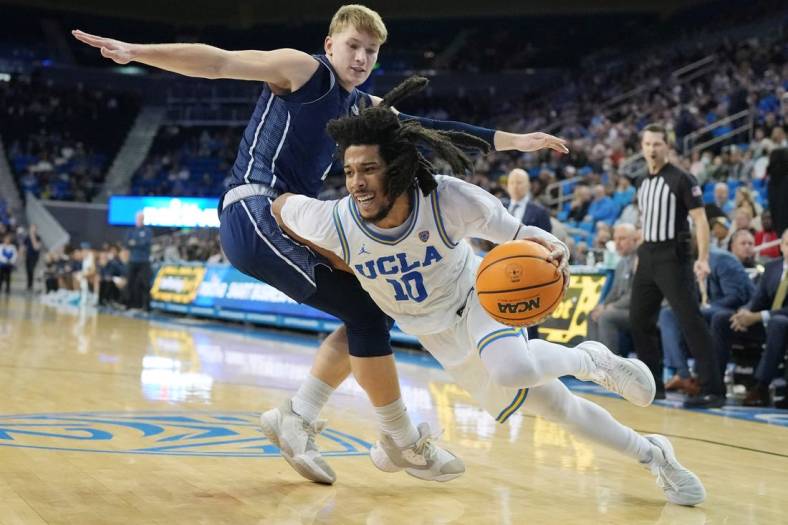 Dec 21, 2022; Los Angeles, California, USA; UCLA Bruins guard Tyger Campbell (right) dribbles the ball against UC Davis Aggies guard Leo DeBruhl in the second half at Pauley Pavilion presented by Wescom. UCLA defeated UC Davis 81-54. Mandatory Credit: Kirby Lee-USA TODAY Sports