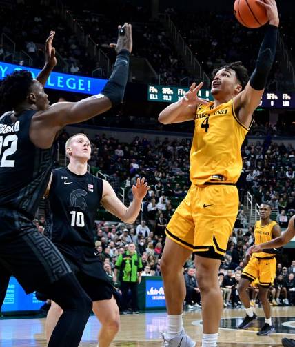Dec 21, 2022; East Lansing, Michigan, USA;  Oakland Golden Grizzlies forward Trey Townsend (4) looks for a shot past Michigan State Spartans center Mady Sissoko (22) at Jack Breslin Student Events Center. Mandatory Credit: Dale Young-USA TODAY Sports