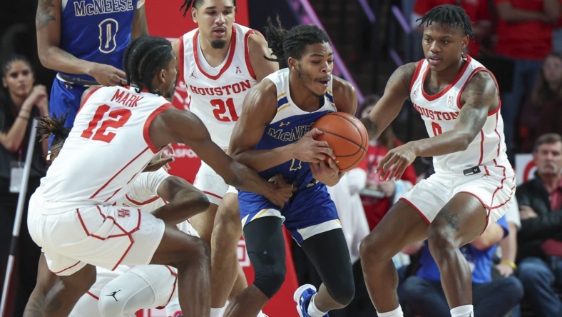 Dec 21, 2022; Houston, Texas, USA; McNeese State Cowboys guard Trae English (1) gets control of a loose ball away from Houston Cougars guard Tramon Mark (12) and guard Marcus Sasser (0) during the first half at Fertitta Center. Mandatory Credit: Troy Taormina-USA TODAY Sports