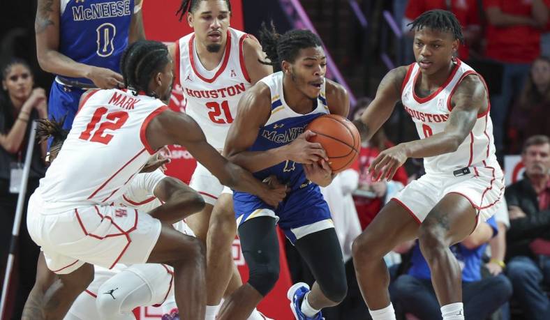 Dec 21, 2022; Houston, Texas, USA; McNeese State Cowboys guard Trae English (1) gets control of a loose ball away from Houston Cougars guard Tramon Mark (12) and guard Marcus Sasser (0) during the first half at Fertitta Center. Mandatory Credit: Troy Taormina-USA TODAY Sports