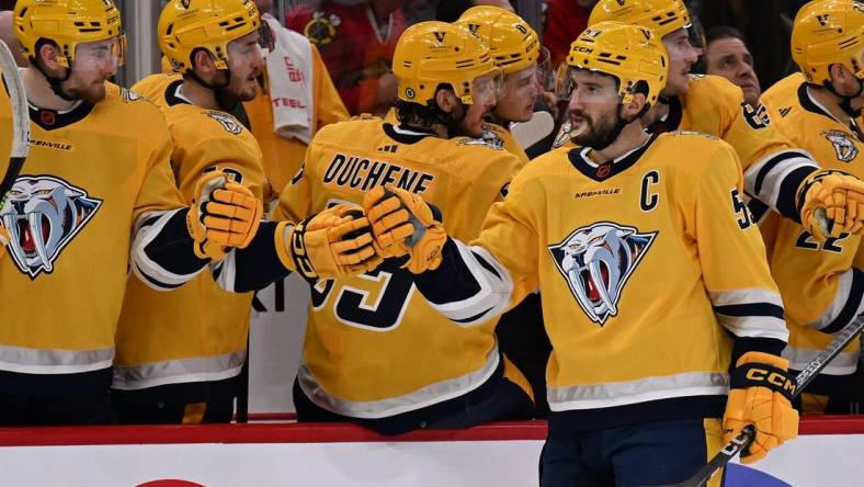 Dec 21, 2022; Chicago, Illinois, USA; Nashville Predators defenseman Roman Josi (59) celebrates at the bench after scoring a goal in the third period against the Chicago Blackhawks at United Center. Nashville defeated Chicago 4-2. Mandatory Credit: Jamie Sabau-USA TODAY Sports