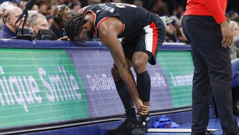 Dec 21, 2022; Oklahoma City, Oklahoma, USA; Portland Trail Blazers forward Justise Winslow (26) grabs his left ankle after a play against the Oklahoma City Thunder during the second half at Paycom Center. Oklahoma City won 101-98. Mandatory Credit: Alonzo Adams-USA TODAY Sports