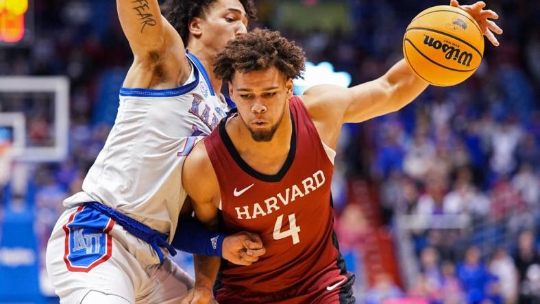 Dec 22, 2022; Lawrence, Kansas, USA; Harvard Crimson forward Chris Ledlum (4) drives against Kansas Jayhawks forward Jalen Wilson (10) during the first half at Allen Fieldhouse. Mandatory Credit: Jay Biggerstaff-USA TODAY Sports