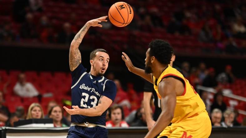 Dec 22, 2022; College Park, Maryland, USA;  St. Peter's Peacocks guard Alex Rivera (23) passes over his head passMaryland Terrapins forward Donta Scott (24) during the first half at Xfinity Center. Mandatory Credit: Tommy Gilligan-USA TODAY Sports