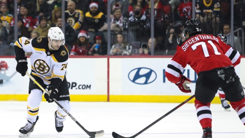 Dec 23, 2022; Newark, New Jersey, USA;  Boston Bruins left wing Jake DeBrusk (74) skates up ice while New Jersey Devils defenseman Jonas Siegenthaler (71) pursues during the first period at Prudential Center. Mandatory Credit: Thomas Salus-USA TODAY Sports