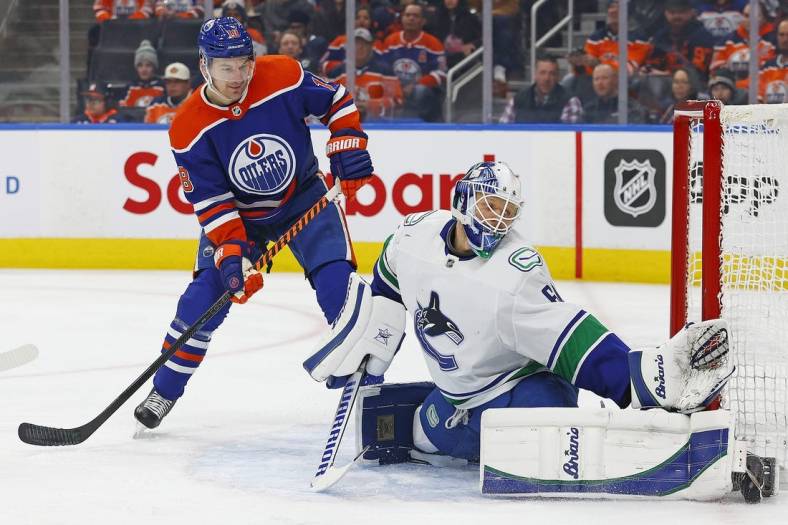 Dec 23, 2022; Edmonton, Alberta, CAN; Vancouver Canucks goaltender Collin Delia (60) makes a save while Edmonton Oilers forward Zach Hyman (18) looks for a rebound during the first period at Rogers Place. Mandatory Credit: Perry Nelson-USA TODAY Sports