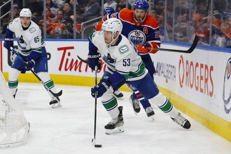 Dec 23, 2022; Edmonton, Alberta, CAN; Vancouver Canucks forward Bo Horvat (53) looks to make a pass in front of Edmonton Oilers forward Leon Draisaitl (29) during the second period at Rogers Place. Mandatory Credit: Perry Nelson-USA TODAY Sports