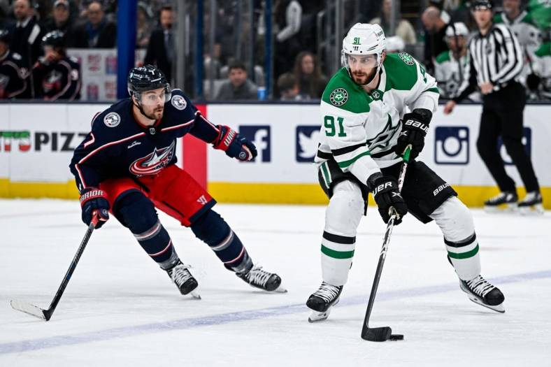 Dec 19, 2022; Columbus, Ohio, USA; Dallas Stars center Tyler Seguin (91) protects the puck from Columbus Blue Jackets center Sean Kuraly (7) in the first period at Nationwide Arena. Mandatory Credit: Gaelen Morse-USA TODAY Sports
