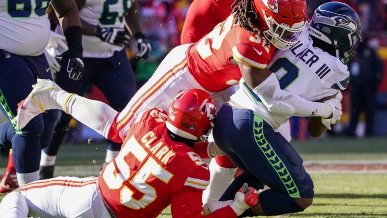 Dec 24, 2022; Kansas City, Missouri, USA; Seattle Seahawks running back Kenneth Walker III (9) is tackled by Kansas City Chiefs defensive end Frank Clark (55) and linebacker Nick Bolton (32) during the first half at GEHA Field at Arrowhead Stadium. Mandatory Credit: Denny Medley-USA TODAY Sports
