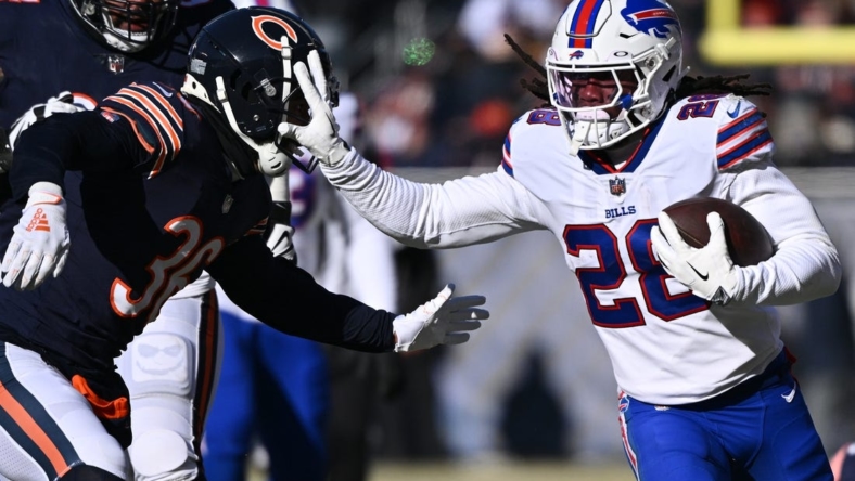Dec 24, 2022; Chicago, Illinois, USA;  Buffalo Bills running back James Cook (28) fends off tackler Chicago Bears defensive back DeAndre Houston-Carson (36) in the first half at Soldier Field. Mandatory Credit: Jamie Sabau-USA TODAY Sports