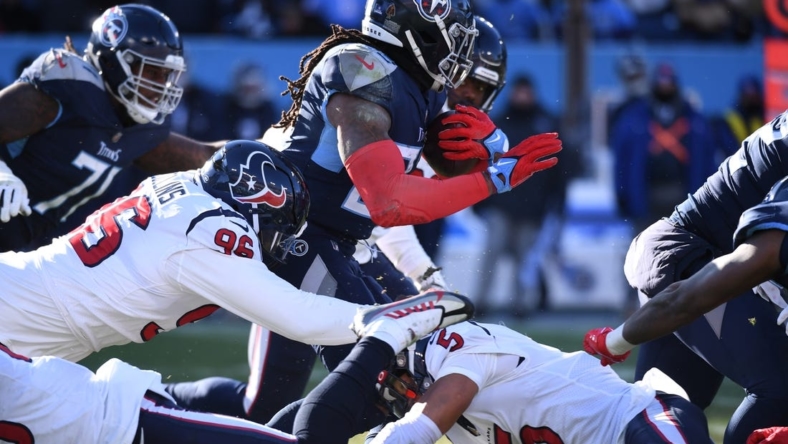 Dec 24, 2022; Nashville, Tennessee, USA; Tennessee Titans running back Derrick Henry (22) is stopped at the line by Houston Texans safety Jalen Pitre (5) and defensive tackle Maliek Collins (96) during the first half at Nissan Stadium. Mandatory Credit: Christopher Hanewinckel-USA TODAY Sports