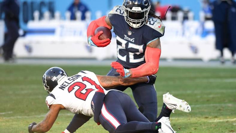 Dec 24, 2022; Nashville, Tennessee, USA; Tennessee Titans running back Derrick Henry (22) fights off a tackle attempt from Houston Texans cornerback Steven Nelson (21) during the second half at Nissan Stadium. Mandatory Credit: Christopher Hanewinckel-USA TODAY Sports