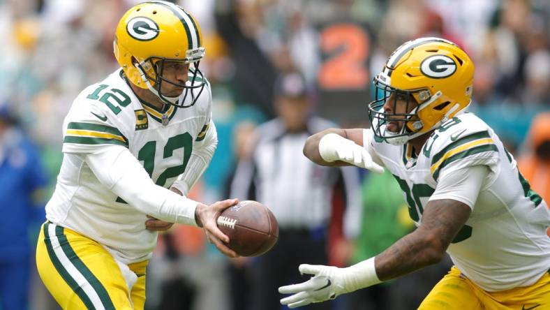 Dec 25, 2022; Miami Gardens, Florida, USA; Green Bay Packers quarterback Aaron Rodgers (12) hands off the football to running back AJ Dillon (28) during the second quarter at Hard Rock Stadium. Mandatory Credit: Sam Navarro-USA TODAY Sports