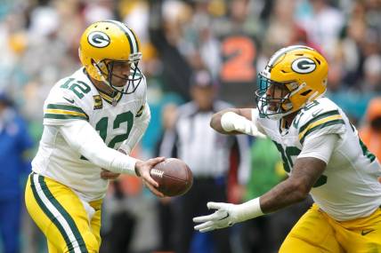 Dec 25, 2022; Miami Gardens, Florida, USA; Green Bay Packers quarterback Aaron Rodgers (12) hands off the football to running back AJ Dillon (28) during the second quarter at Hard Rock Stadium. Mandatory Credit: Sam Navarro-USA TODAY Sports