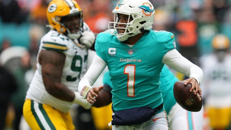 Dec 25, 2022; Miami Gardens, Florida, USA; Miami Dolphins quarterback Tua Tagovailoa (1) scrambles with the ball against the Green Bay Packers during the second half at Hard Rock Stadium. Mandatory Credit: Jasen Vinlove-USA TODAY Sports
