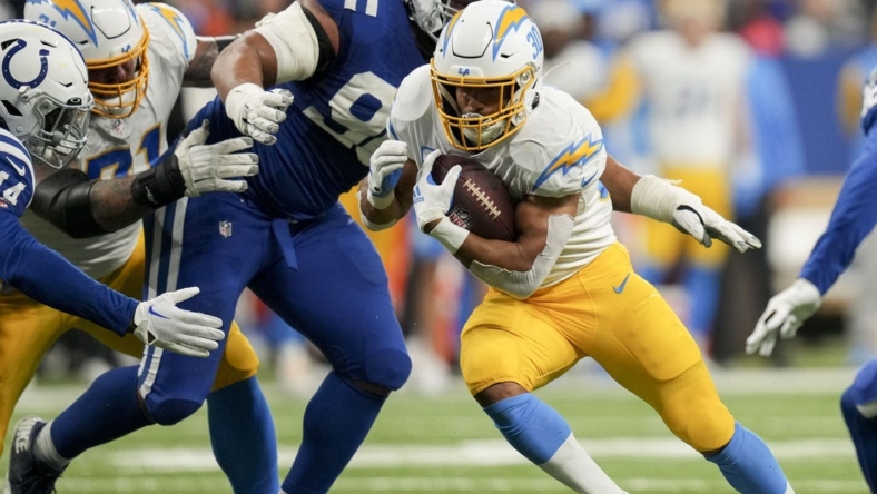 Dec 26, 2022; Indianapolis, Indiana, USA; Los Angeles Chargers running back Austin Ekeler (30) moves past Indianapolis Colts defensive tackle Grover Stewart (90) on Monday, Dec. 26, 2022, during a game against the Los Angeles Chargers at Lucas Oil Stadium in Indianapolis. Mandatory Credit: Jenna Watson-USA TODAY Sports