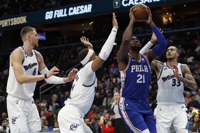 Dec 27, 2022; Washington, District of Columbia, USA;Philadelphia 76ers center Joel Embiid (21) shoots the ball as Washington Wizards center Daniel Gafford (21) and Wizards forward Kyle Kuzma (33) defend in the first quarter at Capital One Arena. Mandatory Credit: Geoff Burke-USA TODAY Sports