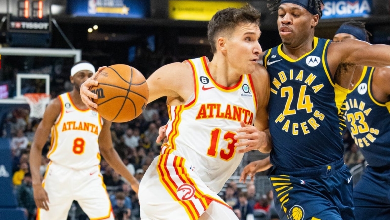 Dec 27, 2022; Indianapolis, Indiana, USA; Atlanta Hawks guard Bogdan Bogdanovic (13) dribbles the ball while Indiana Pacers guard Buddy Hield (24) defends in the first quarter at Gainbridge Fieldhouse. Mandatory Credit: Trevor Ruszkowski-USA TODAY Sports