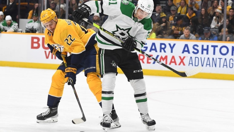 Dec 27, 2022; Nashville, Tennessee, USA; Nashville Predators right wing Nino Niederreiter (22) handles the puck and avoids a hit from Dallas Stars left wing Jason Robertson (21) during the first period at Bridgestone Arena. Mandatory Credit: Christopher Hanewinckel-USA TODAY Sports