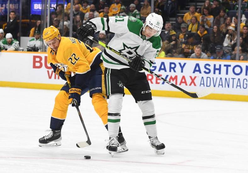 Dec 27, 2022; Nashville, Tennessee, USA; Nashville Predators right wing Nino Niederreiter (22) handles the puck and avoids a hit from Dallas Stars left wing Jason Robertson (21) during the first period at Bridgestone Arena. Mandatory Credit: Christopher Hanewinckel-USA TODAY Sports