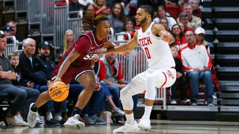 Dec 27, 2022; Lubbock, Texas, USA; South Carolina State Bulldogs forward Davion Everett (55) dribbles the ball against Texas Tech Red Raiders forward Kevin Obanor (0) in the first half at United Supermarkets Arena. Mandatory Credit: Michael C. Johnson-USA TODAY Sports