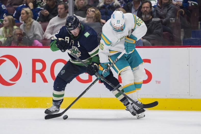 Dec 27, 2022; Vancouver, British Columbia, CAN; Vancouver Canucks forward J.T. Miller (9) battles with San Jose Sharks defenseman Erik Karlsson (65) in the second period at Rogers Arena. Mandatory Credit: Bob Frid-USA TODAY Sports