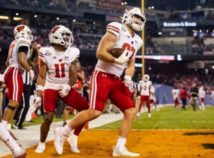 Dec 27, 2022; Phoenix, Arizona, USA; Wisconsin Badgers tight end Hayden Rucci (87) celebrates a touchdown with wide receiver Skyler Bell (11) against the Oklahoma State Cowboys in the first half of the 2022 Guaranteed Rate Bowl at Chase Field. Mandatory Credit: Mark J. Rebilas-USA TODAY Sports