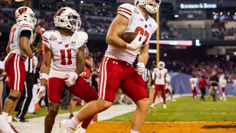 Dec 27, 2022; Phoenix, Arizona, USA; Wisconsin Badgers tight end Hayden Rucci (87) celebrates a touchdown with wide receiver Skyler Bell (11) against the Oklahoma State Cowboys in the first half of the 2022 Guaranteed Rate Bowl at Chase Field. Mandatory Credit: Mark J. Rebilas-USA TODAY Sports