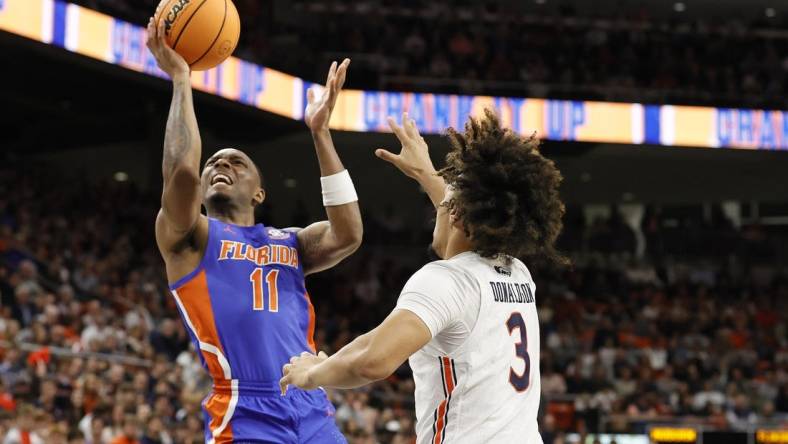 Dec 28, 2022; Auburn, Alabama, USA;  Florida Gators guard Kyle Lofton (11) gets past Auburn Tigers guard Tre Donaldson (3) for a shot during the first half at Neville Arena. Mandatory Credit: John Reed-USA TODAY Sports