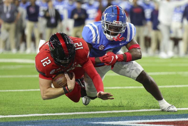 Dec 28, 2022; Houston, Texas, USA; Texas Tech Red Raiders quarterback Tyler Shough (12) falls into the end zone for a touchdown as Mississippi Rebels safety Isheem Young (1) /defends during the first quarter in the 2022 Texas Bowl at NRG Stadium. Mandatory Credit: Troy Taormina-USA TODAY Sports