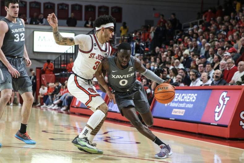 Dec 28, 2022; Queens, New York, USA;  Xavier Musketeers guard Souley Boum (0) drives past St. John's Red Storm guard Andre Curbelo (3) in the first half at Carnesecca Arena. Mandatory Credit: Wendell Cruz-USA TODAY Sports