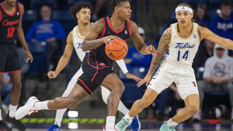 Dec 28, 2022; Tulsa, Oklahoma, USA;  Houston Cougars guard Marcus Sasser (0) dribbles past Tulsa Golden Hurricane guard Anthony Pritchard (14) during the first half at Reynolds Center. Mandatory Credit: Brett Rojo-USA TODAY Sports