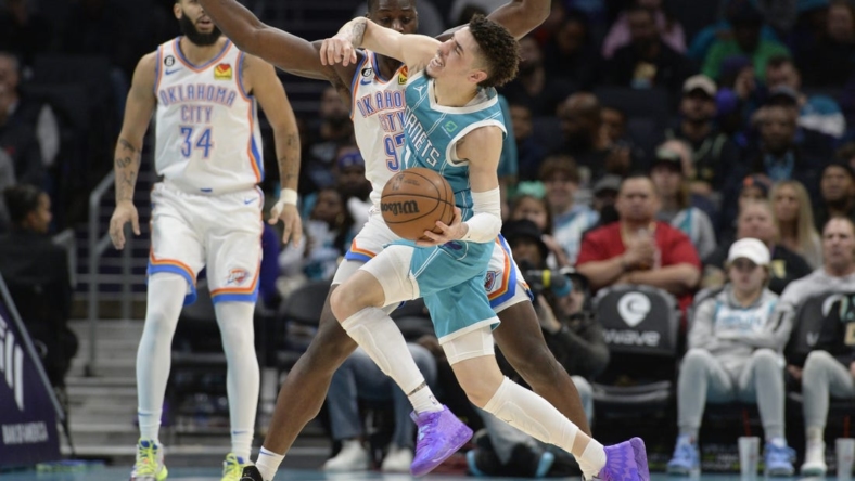 Dec 29, 2022; Charlotte, North Carolina, USA; Charlotte Hornets guard LaMelo Ball (1) is fouled by Oklahoma City Thunder forward Eugene Omoruyi (2) during the first half at the Spectrum Center. Mandatory Credit: Sam Sharpe-USA TODAY Sports