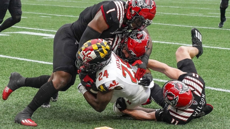 Dec 30, 2022; Charlotte, NC, USA; North Carolina State Wolfpack linebacker Isaiah Moore (1) and linebacker Payton Wilson (11) stop Maryland Terrapins running back Roman Hemby (24) on fourth down during the first half in the 2022 Duke's Mayo Bowl at Bank of America Stadium. Mandatory Credit: Jim Dedmon-USA TODAY Sports