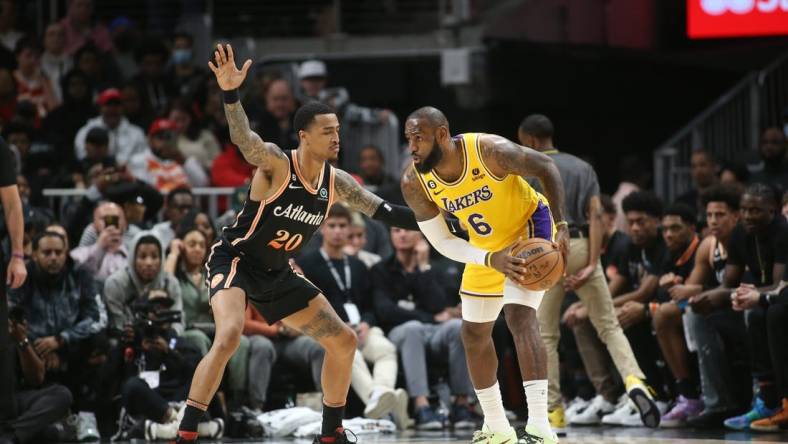 Dec 30, 2022; Atlanta, Georgia, USA; Atlanta Hawks forward John Collins (20) defends Los Angeles Lakers forward LeBron James (6) in the second quarter at State Farm Arena. Mandatory Credit: Brett Davis-USA TODAY Sports