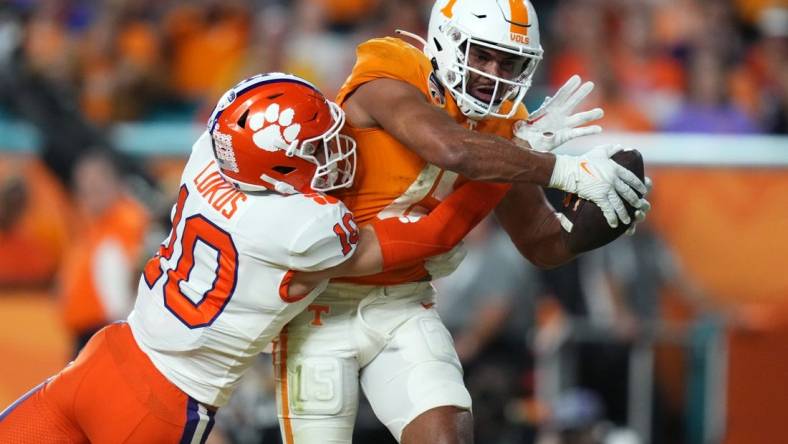 Dec 30, 2022; Miami Gardens, FL, USA; Tennessee Volunteers wide receiver Bru McCoy (15) scores a touchdown past Clemson Tigers cornerback Jeadyn Lukus (10) during the first half of the 2022 Orange Bowl at Hard Rock Stadium. Mandatory Credit: Jasen Vinlove-USA TODAY Sports