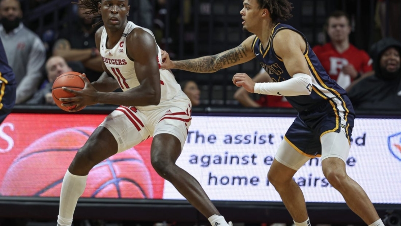 Dec 30, 2022; Piscataway, New Jersey, USA; Rutgers Scarlet Knights center Clifford Omoruyi (11) dribbles against Coppin State Eagles forward Luka Tekavcic (33) during the first half at Jersey Mike's Arena. Mandatory Credit: Vincent Carchietta-USA TODAY Sports