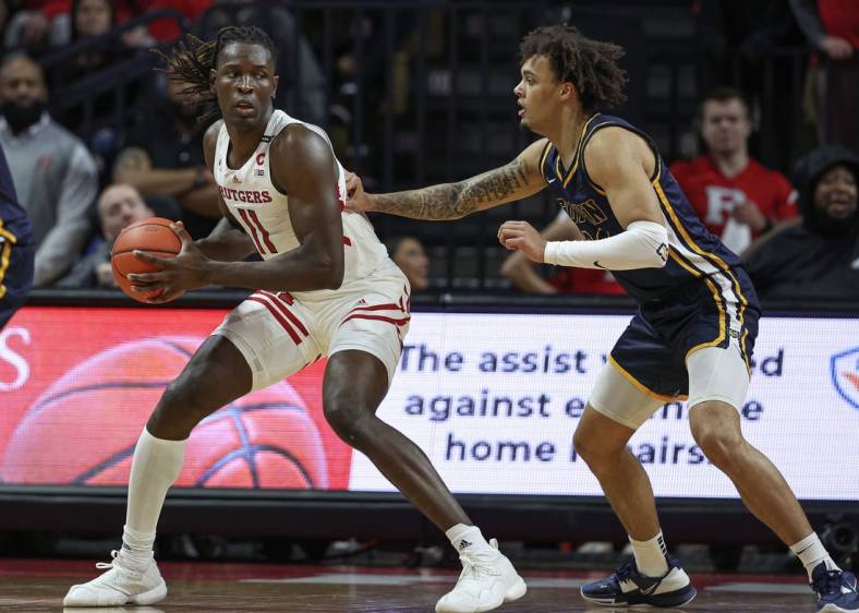 Dec 30, 2022; Piscataway, New Jersey, USA; Rutgers Scarlet Knights center Clifford Omoruyi (11) dribbles against Coppin State Eagles forward Luka Tekavcic (33) during the first half at Jersey Mike's Arena. Mandatory Credit: Vincent Carchietta-USA TODAY Sports