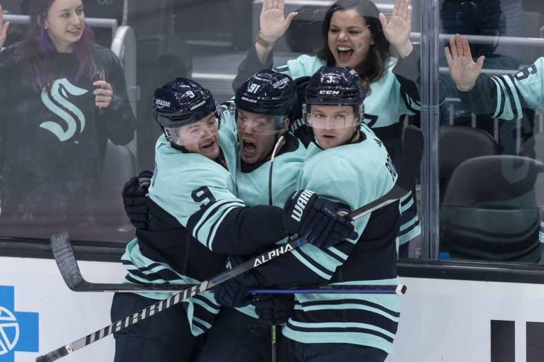 Dec 30, 2022; Seattle, Washington, USA; Seattle Kraken forward Daniel Sprong (91) is congratulated by forward Ryan Donato (9) and defenseman Will Borgen (3) after scoring a goal during the second period against the Edmonton Oilers at Climate Pledge Arena. Mandatory Credit: Stephen Brashear-USA TODAY Sports