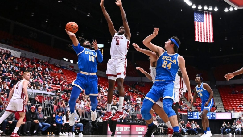 Dec 30, 2022; Pullman, Washington, USA; UCLA Bruins guard Tyger Campbell (10) shoots the ball against Washington State Cougars guard Kymany Houinsou (31) in the first half at Friel Court at Beasley Coliseum. Mandatory Credit: James Snook-USA TODAY Sports