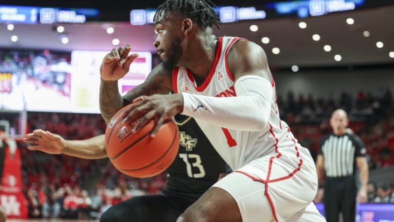 Dec 31, 2022; Houston, Texas, USA; Houston Cougars guard Jamal Shead (1) drives with the ball as Central Florida Knights guard C.J. Kelly (13) defends during the first half at Fertitta Center. Mandatory Credit: Troy Taormina-USA TODAY Sports