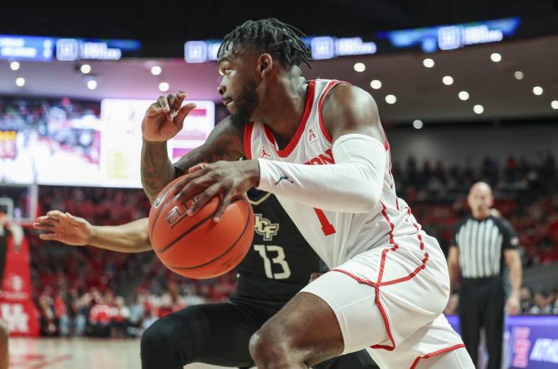 Dec 31, 2022; Houston, Texas, USA; Houston Cougars guard Jamal Shead (1) drives with the ball as Central Florida Knights guard C.J. Kelly (13) defends during the first half at Fertitta Center. Mandatory Credit: Troy Taormina-USA TODAY Sports