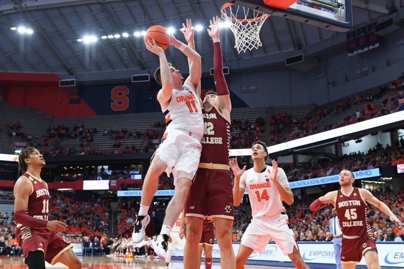 Dec 31, 2022; Syracuse, New York, USA; Syracuse Orange guard Joseph Girard III (11) shoots the ball as Boston College Eagles forward Quinten Post (12) defends during the first half at the JMA Wireless Dome. Mandatory Credit: Rich Barnes-USA TODAY Sports