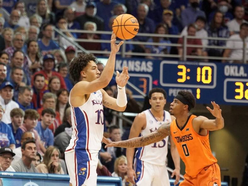 Dec 31, 2022; Lawrence, Kansas, USA; Kansas Jayhawks forward Jalen Wilson (10) passes as Oklahoma State Cowboys guard Avery Anderson III (0) defends during the first half at Allen Fieldhouse. Mandatory Credit: Denny Medley-USA TODAY Sports