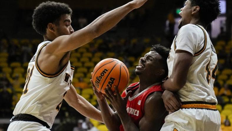 Dec 31, 2022; Laramie, Wyoming, USA; Wyoming Cowboys guard Noah Reynolds (21) and forward Caden Powell (44) trap New Mexico Lobos guard Jamal Mashburn Jr. (5) during the first half at Arena-Auditorium. Mandatory Credit: Troy Babbitt-USA TODAY Sports